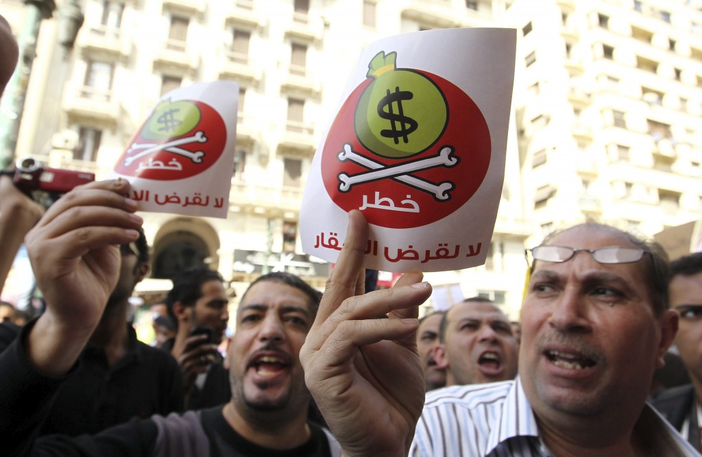 Un grupo de egipcios muestra unos carteles en los que se lee "Dólares = peligro" en árabe